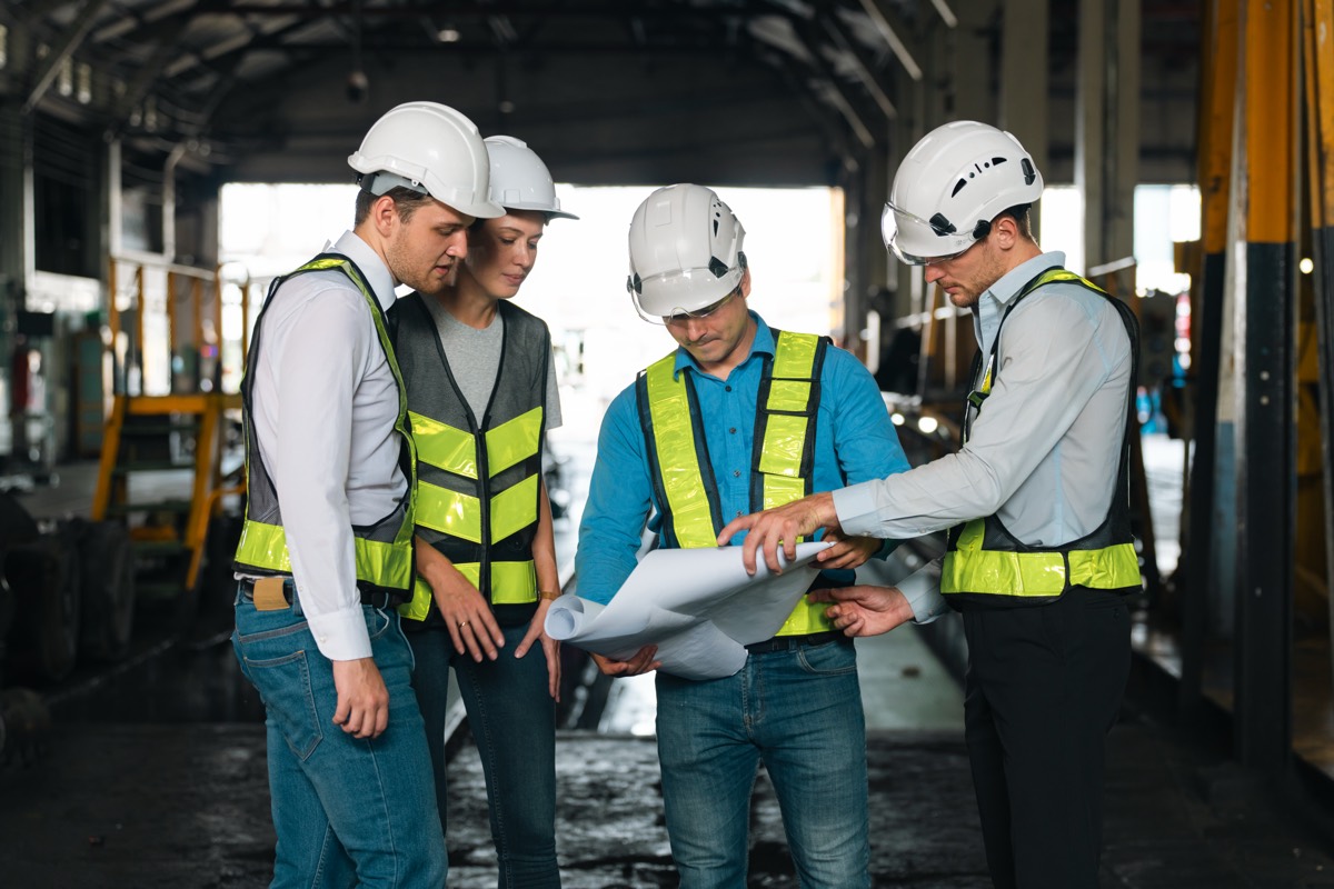 Project team reviewing plans in an industrial setting